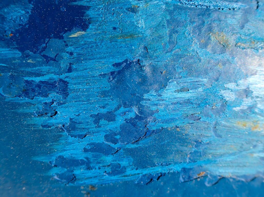 Dynamic blue abstract painting featuring textured brushstrokes and rich acrylic colors.